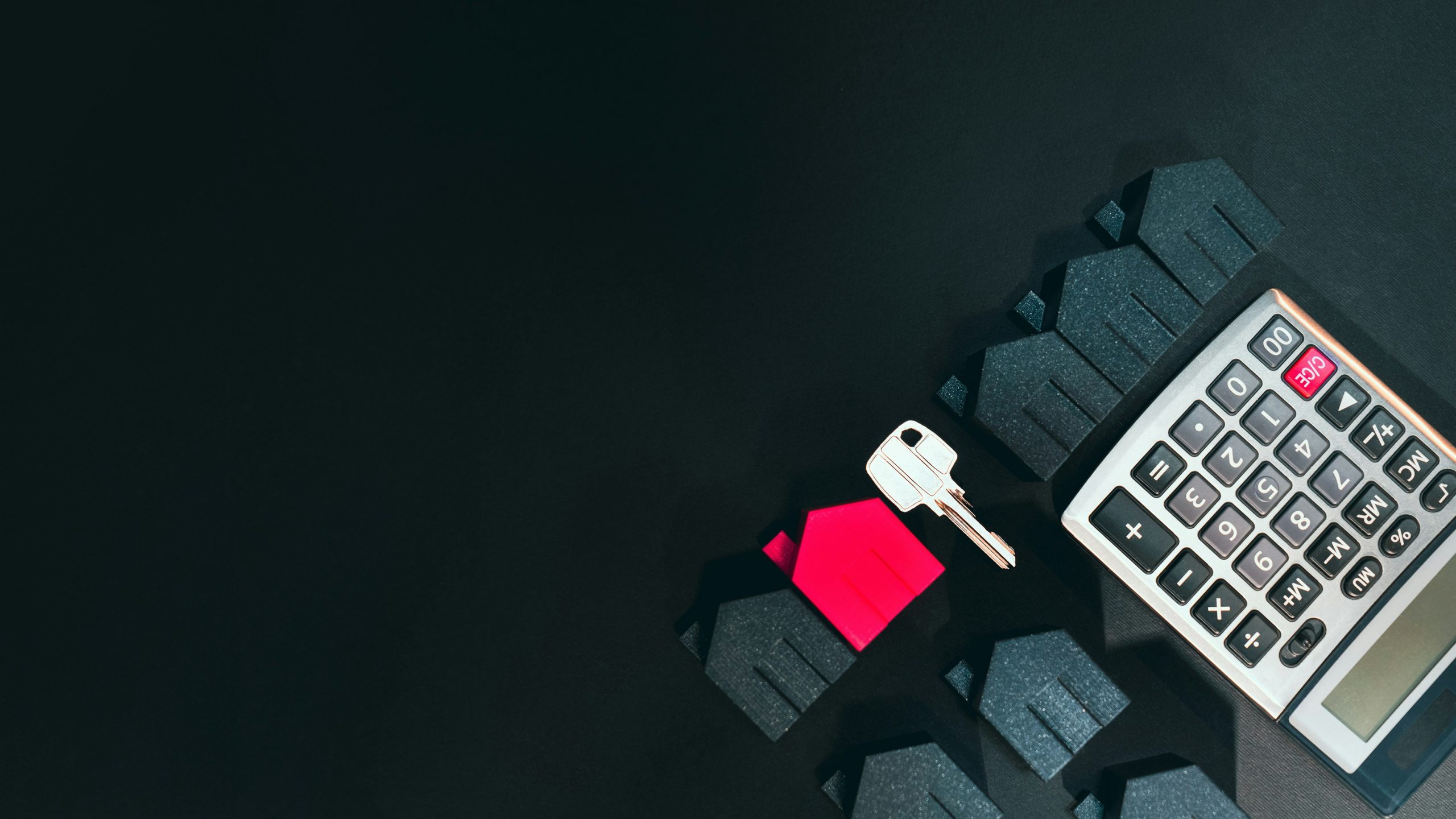 miniature houses, key, and calculator